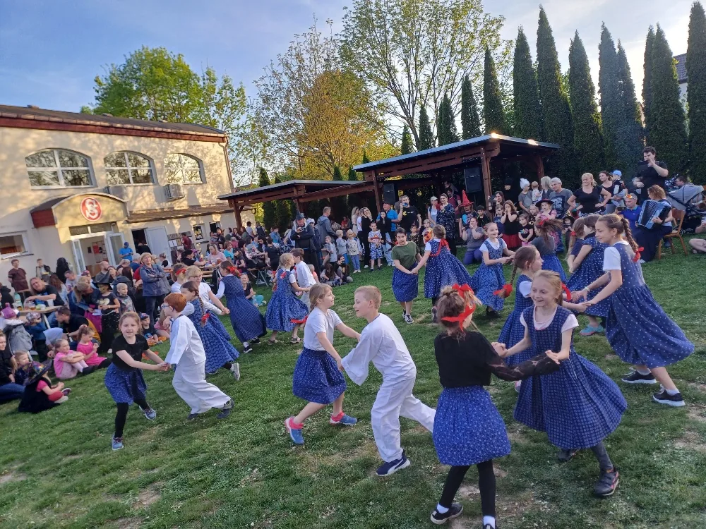 Děti ze školního folklorního kroužku tančí na sokolské louce